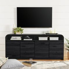 a flat screen tv mounted to the side of a black entertainment center