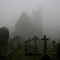 an old cemetery with tombstones in the fog