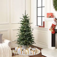 a christmas tree with presents under it in a living room