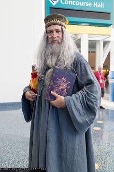 an old man with a long white beard wearing a robe and holding a book in his hand