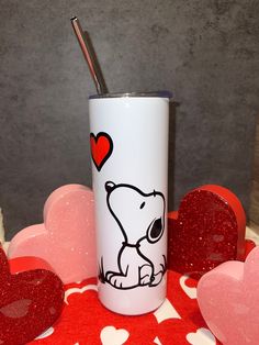 a cup with a straw in the shape of a bear on it and hearts around it