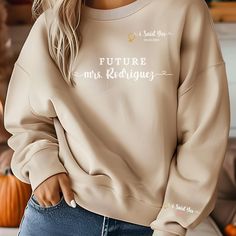 a woman wearing a beige sweatshirt with the words, future mrs radisigns on it