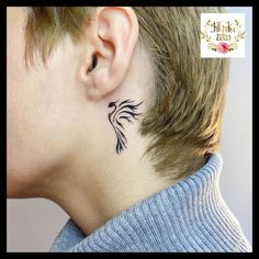 a woman's neck with a small bird tattoo on her left side behind the ear