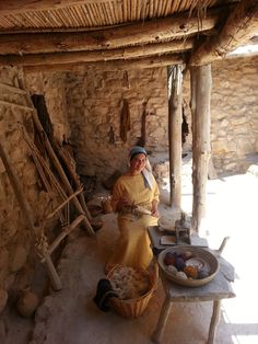 a woman sitting in front of a basket filled with food on top of a table