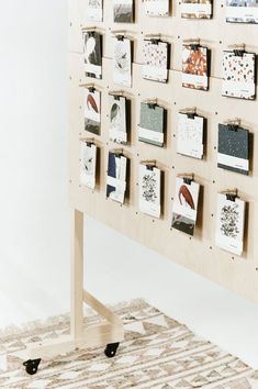 a wooden board with pictures on it and wheels attached to the back of it in front of a white wall