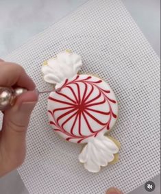 someone is decorating a christmas cookie with icing and candy canes on it