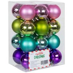 assorted christmas ornaments in a clear box with red and green tags on the bottom