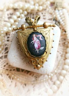 Beautiful Antique French XIX-Century Enamelled Miniature Painting Locket Pendant Victorian Ornate Reliquary with Thick Bevelled Glass Window, Rare Gift for Woman Size - Shield part itself (without hangings) - approx. 34x32,8mm/ 1,34" x 1,29" Oval part with a painting - approx. 21x16mm / 0,83" x 0,62" Width - approx. 10,4mm / 0,41" Total size (with hanging part) -  approx. 49x37,9" / 1,93" x 1,49" Pendant is in a great antique condition, thick and very high quality, beautifully detailed, with uni Victorian Locket Necklace With Antique Finish For Collectible, Ornate Pendant Locket Necklace Collectible, Victorian Brass Locket Necklace For Vintage Collection, Victorian Oval Brass Locket Necklace, Antique Enamel Locket Necklace, Vintage Wedding Jewelry, Rare Gifts, Locket Necklace, Miniature Painting