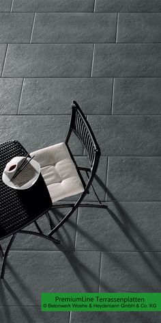 a table and chair sitting on top of a cement floor next to a brick wall