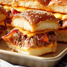 three cheeseburger sandwiches sitting on top of a tray