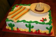 a cake decorated with green and yellow frosting has a hat on top of it