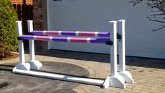 a purple and white barrier sitting in front of a garage door next to a driveway