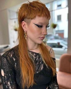 a woman with long red hair and black makeup