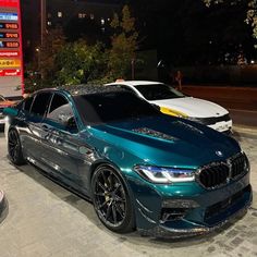 two cars parked next to each other in front of a gas station