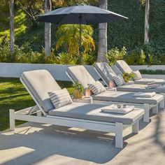 a row of lounge chairs with an umbrella over them