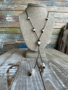 This necklace is simple yet elegant.  I chose a dark brown antiqued and distressed leather. There are freshwater cultured pearls stationed in 4 places along the strands of leather in the neck area.  The pearls are barrel knotted and secured at both ends.  The center  of the necklace is the focal point.  It is a  large baroque freshwater cultured pearl. The pearl is secured and knotted in the center. There are also strands of leather threaded through it to create the tassel at the bottom.  At the ends of the tassels are teardrop shaped pearls. They are knotted and secured and dangle at the ends of the leather.  This necklace has a very classic look and works well with so many different styles. A great accent piece for a simple t-shirt and jeans, coastal or western wear, and it would look am Country Style Wedding Dresses, Country Style Wedding, Simple T Shirt, Leather Thread, Simple Tshirt, Freshwater Cultured Pearls, T Shirt And Jeans, Distressed Leather, Leather Necklace