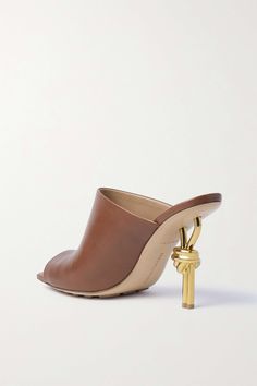 Find BOTTEGA VENETA Knot Leather Mules on Editorialist. Bottega Veneta's mules sit on 85mm gold-tone heels that look as if they've been tied into a knot. Made from supple leather, they have distinct square toes and rubber grips on the sole to keep you from slipping. Chic Gold Mules With 4-inch Heel, Luxury Mules With Wrapped Heel For Cocktail, Elegant Gold Mules For Workwear, Gold Calf Leather Open Toe Heels, Gold Calf Leather Heels With Pointed Toe, Gold Open Toe Heels In Calf Leather, Gold Open Toe Calf Leather Heels, Chic Gold Calf Leather Heels, Luxury Brown Mules For Party