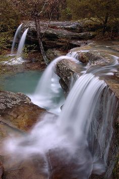 there is a waterfall in the middle of some rocks