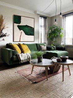 a living room filled with green couches and a coffee table in front of a window