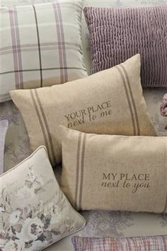 four pillows with embroidered sayings on them