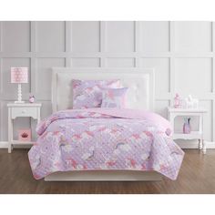 a white bed with pink and purple unicorns on it