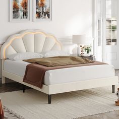 a white bed sitting in a bedroom on top of a rug