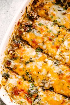 a casserole dish with cheese and spinach in it on a counter top