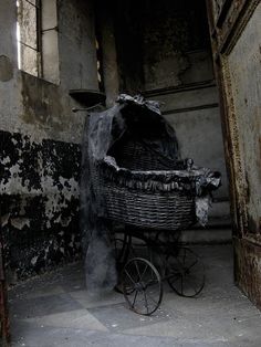 an old fashioned baby carriage in the corner of a building