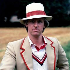 a man in a suit and hat poses for the camera