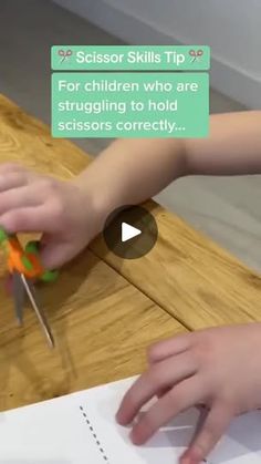 a person cutting up some paper with scissors on top of a wooden table next to a sign that says scissor skills tip for children who are struggling to hold scissors correctly