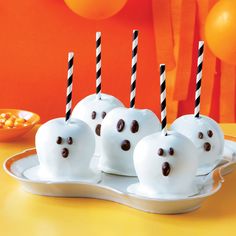 there are some white chocolate balls with ghost faces on them and candles in the middle