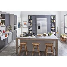 a kitchen with two stools at the island