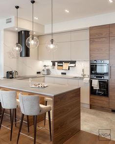 a modern kitchen with an island and bar stools