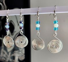 three pairs of earrings hanging from a rack