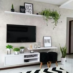 there is a television on the wall in this living room with black and white decor