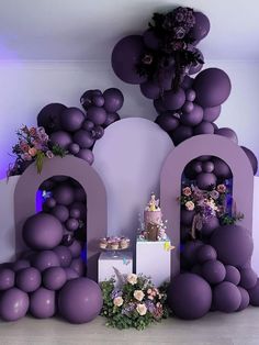 an image of balloons and flowers on the floor in front of a wall with letters