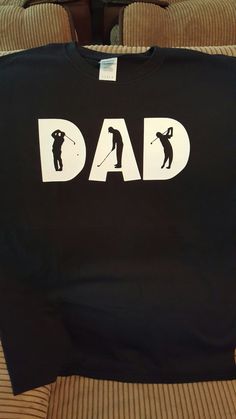 a t - shirt that says dad on it with a golf player in the background