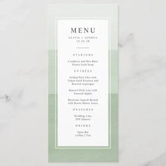 a white and green menu card sitting on top of a table