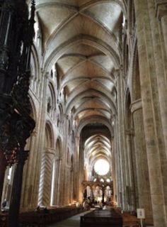 the inside of an old cathedral with pews and stone arches on either side of the navel