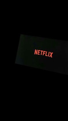 the netflix sign is lit up in the dark with red light on it's side