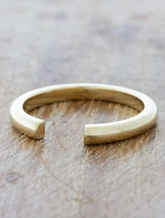 a thin gold ring sitting on top of a wooden table