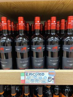 bottles of red wine are on display in a grocery store for $ 5 per bottle