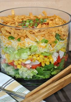 a glass bowl filled with salad and chips