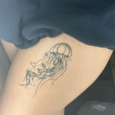 a woman's thigh with a jellyfish tattoo on it