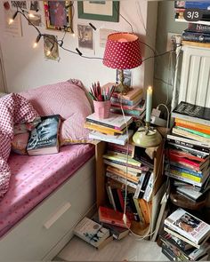 a bedroom with a bed and lots of books on the shelf next to it,