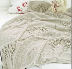 a teddy bear sitting on top of a bed next to a white blanket and pillows