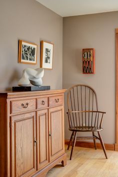 a chair sitting on top of a wooden dresser