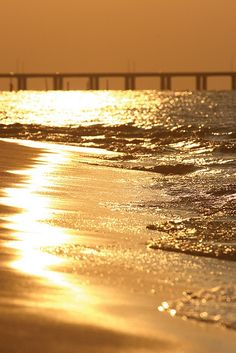 the sun is shining on the water at the beach