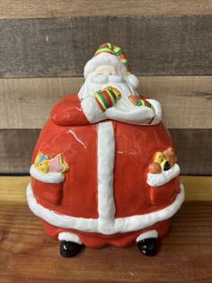 a santa clause figurine sitting on top of a wooden table