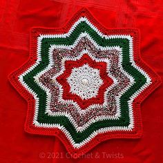 a crocheted red and green doily with a white center